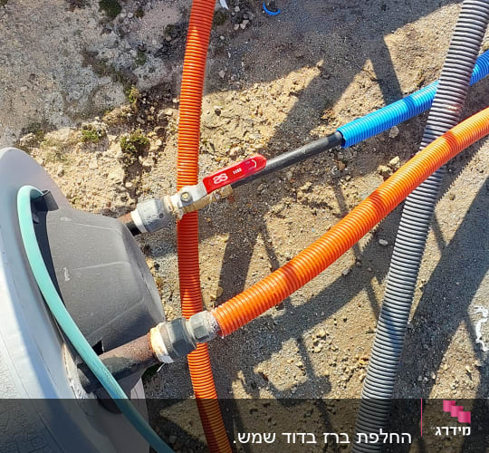 צינורות צבעוניים מחוברים לדוד שמש על גג